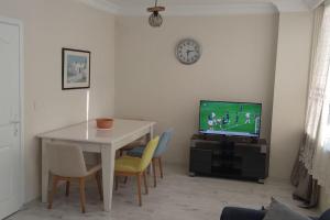 een woonkamer met een tafel en een televisie bij MCKızılsaray Apart in Antalya
