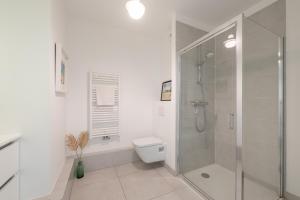a white bathroom with a shower and a toilet at Disneyland 5 min -Paris 35 min -2/4 personnes in Montévrain +29 photos