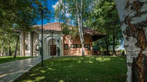 dom z zielonym trawnikiem przed nim w obiekcie Garni Hotel Plava Laguna w mieście Ćuprija