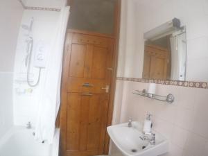 a bathroom with a sink and a wooden door at Carlton Mansions - The Red Room in Bristol +4 photos