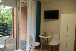 a room with a balcony with a table and chairs at Atlanta in Mrzeżyno