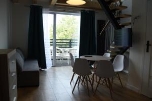 a dining room with a table and chairs and a balcony at Atlanta in Mrzeżyno
