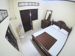una vista sul soffitto di una camera da letto con letto e specchio di Joglo Sempu Homestay Jogja a Yogyakarta