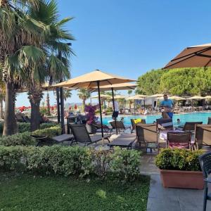 a group of chairs and umbrellas next to a pool at Villa Pearl Adriatic Coast in Golem +24 photos