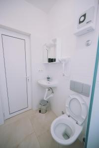 een witte badkamer met een toilet en een wastafel bij Apartments Leandra in Ulcinj +50 foto's
