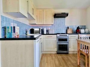 a kitchen with white cabinets and a stove top oven at Spacious cabin, near Padstow and 7 Bays in St Merryn +19 photos