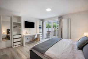 ein Schlafzimmer mit einem Bett und einem Schreibtisch mit einem Fernseher in der Unterkunft He, wat mooi in Lübeck