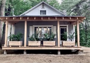 a small house with a porch with two benches at La Petite Maison in Rawdon