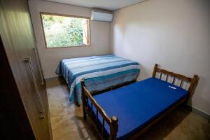 a small bedroom with two beds and a window at Casa de campo com piscina próxima ao aeroporto de Dourados in Dourados