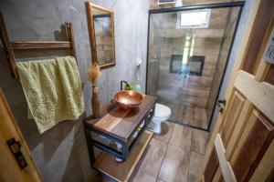 a bathroom with a sink and a toilet and a shower at Casa de campo com piscina próxima ao aeroporto de Dourados in Dourados