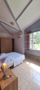 a bedroom with a large bed and a window at Hotel La Chaumiere in Matoury