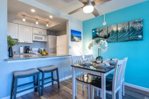 a kitchen and dining room with a table and chairs at Kamaole Beach Royale 208 in Kihei