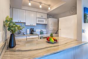 a kitchen with a bowl of fruit on a counter at Kamaole Beach Royale 208 in Kihei