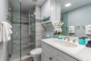 a bathroom with a toilet and a sink and a shower at Kamaole Beach Royale 208 in Kihei