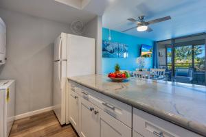 a kitchen with white appliances and a white refrigerator at Kamaole Beach Royale 208 in Kihei
