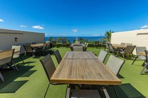 a patio with tables and chairs and the ocean at Kamaole Beach Royale 208 in Kihei