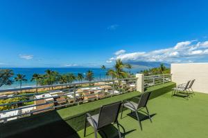 a balcony with chairs and a view of the ocean at Kamaole Beach Royale 208 in Kihei