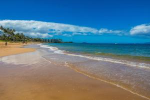a sandy beach with the ocean and buildings in the background at Kamaole Beach Royale 208 in Kihei