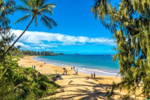 people on a beach with palm trees and the ocean at Kamaole Beach Royale 208 in Kihei