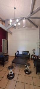 a living room with a couch and two stools at Hotel La Chaumiere in Matoury