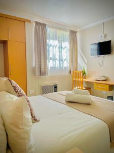 a bedroom with a large white bed with a chair at LA Diamond Lodge & Safari in Lime Acres