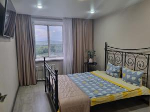 a bedroom with a bed and a large window at Набережная Иртыша с красивым видом на реку in Ustʼ-Kamenogorsk