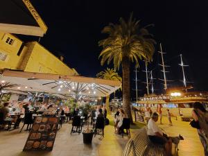 un gruppo di persone sedute ai tavoli su un molo di notte di Apartman Dubrovnik a Trogir