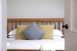 a bed with yellow and white pillows on it at Luxury Pet-Friendly Retreat with Private Hot Tub in Boardmills