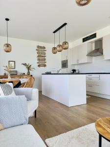 a kitchen and living room with white cabinets and a table at Nwptment in Nieuwpoort