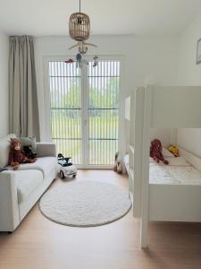 a baby room with a white couch and a crib at Nwptment in Nieuwpoort +19 photos
