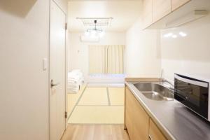 a kitchen with a sink and a counter top at 【SHO-HOUSE】駅から徒歩3分 in Osaka