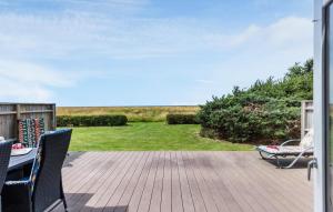 巴恩科普Three-Bedroom Holiday Home Bagenkop With Sea View 04的露台上有一张桌子和几把椅子