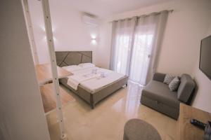 een kleine kamer met een bed en een bank bij Apartments Leandra in Ulcinj