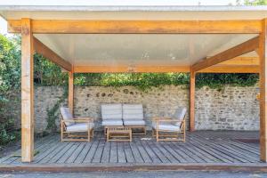 two chairs sitting on a porch with a pavilion at maison de campagne toute équipée 5km de Thoiry in Saulx-Marchais