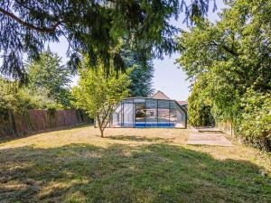 a glass house with a tree in the yard at maison de campagne toute équipée 5km de Thoiry in Saulx-Marchais +26 photos