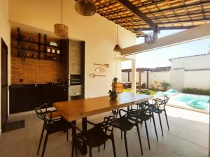 a dining room with a wooden table and chairs at Horizonte Azul in Búzios
