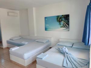 a room with two beds and a picture on the wall at Blue Apartahotel Coveñas in Coveñas +65 photos