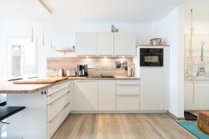 a white kitchen with white cabinets and a sink at Paddel Nr 5 in Neustadt in Holstein