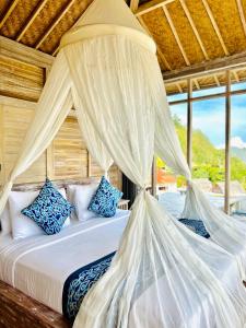 a bedroom with a bed with white mosquito nets at The volcano in Kubupenlokan