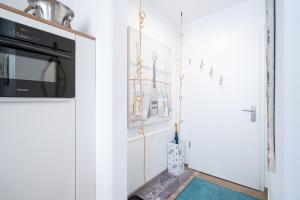 a kitchen with white walls and a door with a microwave at Paddel Nr 5 in Neustadt in Holstein +24 photos