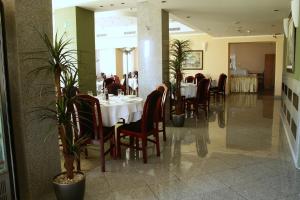 ein Esszimmer mit Tischen, Stühlen und Pflanzen in der Unterkunft Hotel Elegance in Belgrad