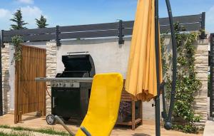 un ombrello giallo e una griglia in un cortile di Casa Briscola a Marčana Altre 16 foto