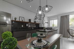 a kitchen with a table and a dining room at Apto em cond Thai Beach Home Spa TBS1105 in Florianópolis