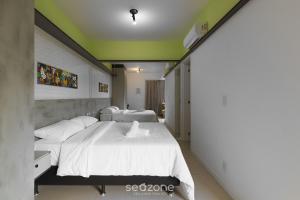a bedroom with two beds with white sheets at Apto em cond Thai Beach Home Spa TBS1105 in Florianópolis +25 photos