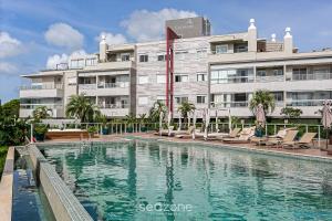 a hotel with a swimming pool in front of a building at Apto em cond Thai Beach Home Spa TBS1105 in Florianópolis
