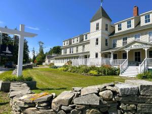 a cross in front of a large house with a stone wall at Hotel Pemaquid in Bristol
