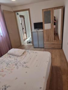 ein Schlafzimmer mit einem Bett und einer Tür mit einem Fernseher in der Unterkunft ADC&Studio in Constanţa + 4 Fotos