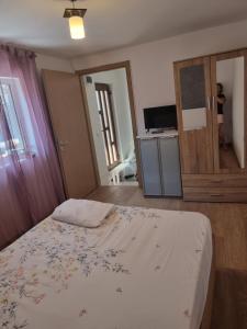 ein Schlafzimmer mit einem Bett und einem Fernseher in der Unterkunft ADC&Studio in Constanţa