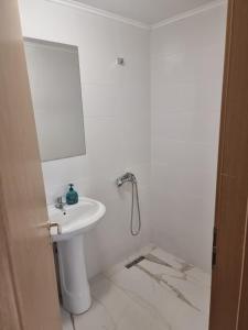ein weißes Badezimmer mit Waschbecken und Spiegel in der Unterkunft ADC&Studio in Constanţa
