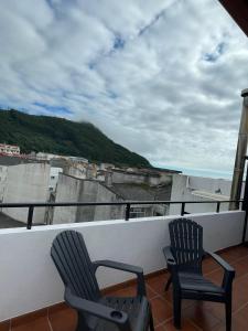 Dos sillas sentadas encima de un balcón. en Ático, en A Guarda